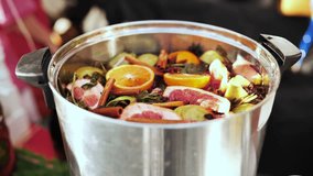 Mulled wine simmering in pot with cinnamon sticks, orange and grapefruit slices - Powered by Shutterstock - Get 15% off with code: PIKWIZARD15