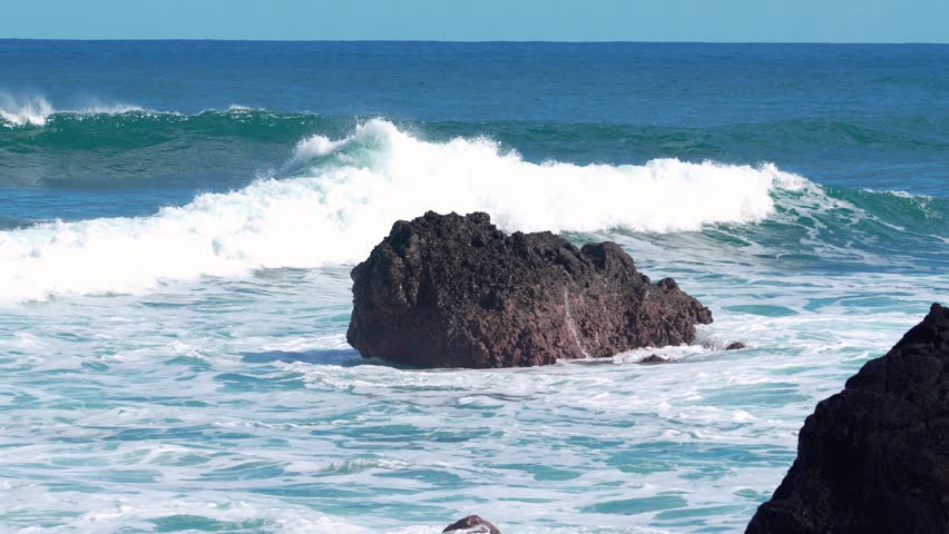 Waves crashing on rocky shores in Madeiras stunning coastal beauty