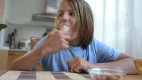 Young child eating ice cream in a cone at home kitchen table. Natural light, cozy atmosphere, sweet treat and joyful moment in casual everyday setting - Powered by Shutterstock - Get 15% off with code: PIKWIZARD15