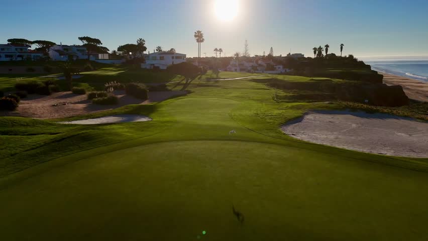 An aerial footage of coastal green cliffs overlooking the Atlantic Ocean in Algarve, Portugal at sunrise