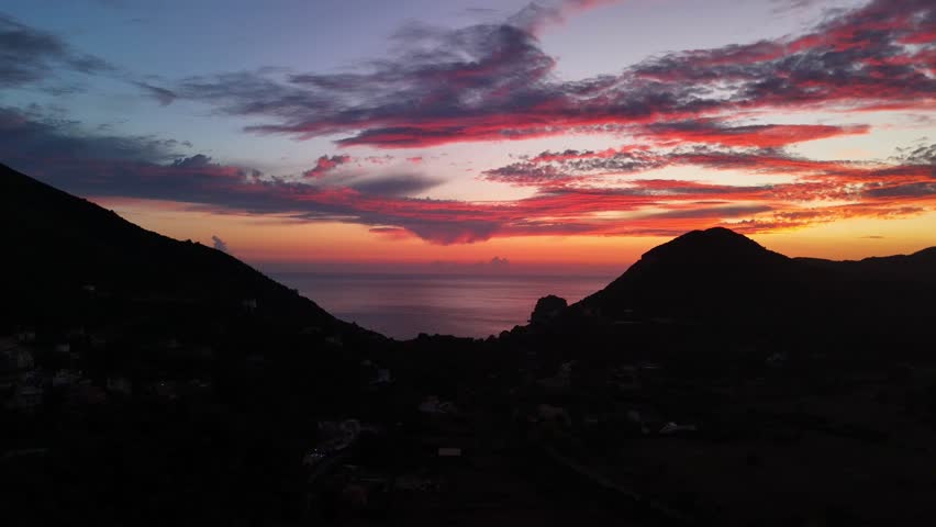 Vibrant sunset over hills with colorful clouds, calm and peaceful mood
