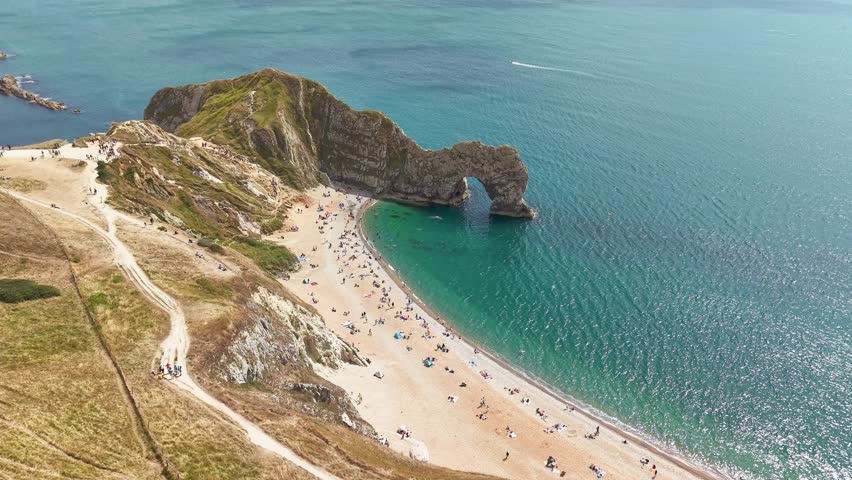 Aerial drone footage showing tourists on beach at Durdle Door, Dorset, England
