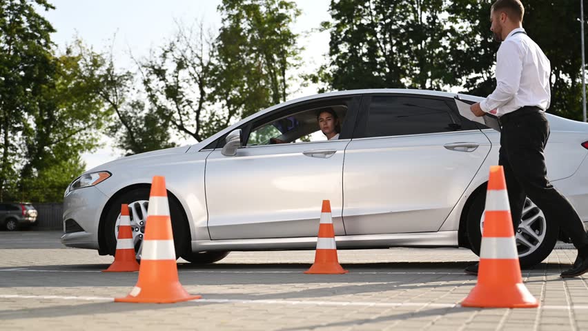 Standing by the car, the results of drive. Woman is trying to pass exam in the driving school.
