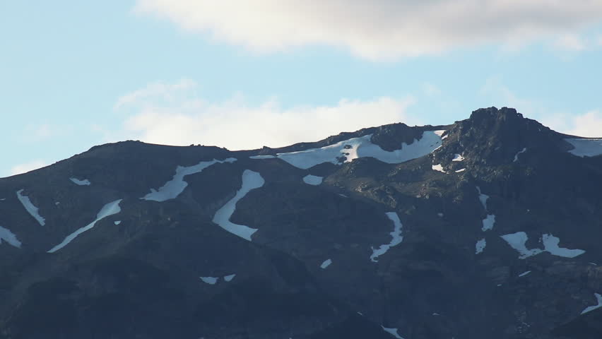Close telephoto of rocky Andean ridge with lingering snowfields — static tripod, Patagonia, Argentina