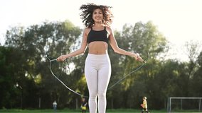 Jumping rope, active. Young fitness woman is on the field outdoors. - Powered by Shutterstock - Get 15% off with code: PIKWIZARD15
