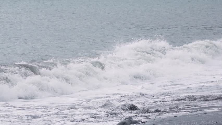 Waves crash on a tranquil shore as natures beauty unfolds in slow motion