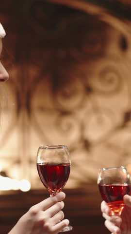 Romantic toast with red wine glasses by fireplace