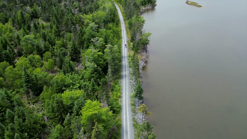 cyclist riding a bike on a path trail by the lake shore swap