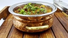 Hearty Indian Curry Served in Silver Pot, Vegetarian Legume Dish Garnished with Fresh Herb, Rustic Meal on Wooden Tray, Spiced Lentil Delight along Cilantro Topper, Home Cooked Food Feature Rich Gravy - Powered by Shutterstock - Get 15% off with code: PIKWIZARD15