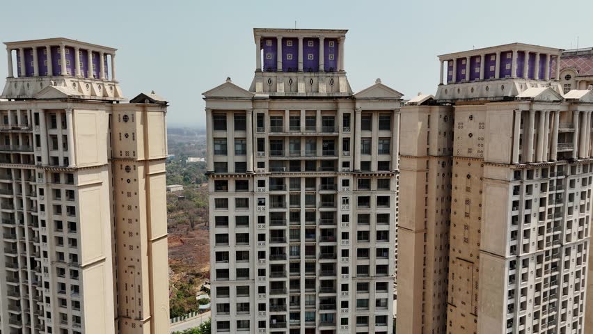 Drone shot multi story skyscraper above landscaped, Aerial show tall apartments with stylish exteriors, Residential units offer panoramic outdoor views, Luxury Flats Elevate Countryside Housing Trend
