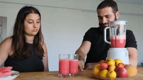Happy Middle Eastern couple clinking glasses with watermelon smoothies, smiling and enjoying each other s company. Bearded husband and beautiful wife sharing a refreshing summer drink together. - Powered by Shutterstock - Get 15% off with code: PIKWIZARD15