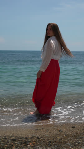Woman beach ocean, standing in shallow water enjoying peaceful summer day. Vertical video