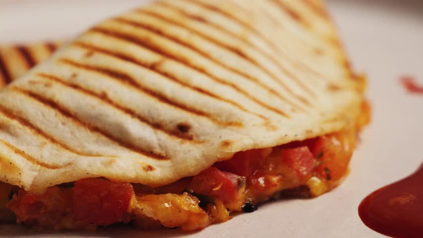 Traditional Mexican food quesadilla with pulled pork, beans and lots of cheese served with traditional Mexican sauce Valentina.