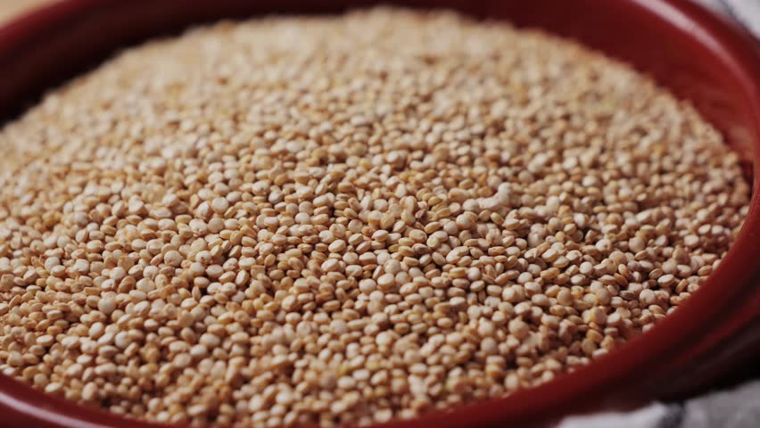 White quinoa in bowl, close-up. Quinoa seeds are rich in protein, vitamins and minerals. Healthy nutrition, vegan food.