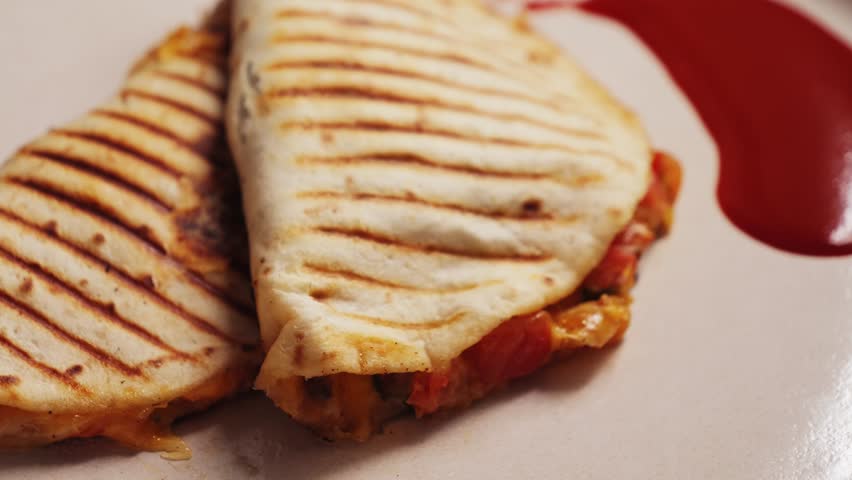Traditional Mexican food quesadilla with pulled pork, beans and lots of cheese served with traditional Mexican sauce Valentina.