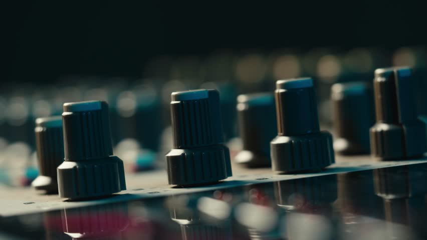Music studio close up, Close up hands shot of sound engineer using mixing console, remote control for adjusting sound, audio mixer. Musician creates music, makes remix for DJ set. Sound recording