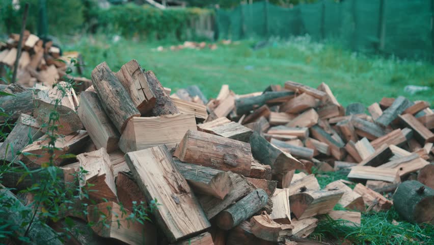 Split Firewood Chunks Ready for Use | Chopped Wood Pile in Rural Backyard | Close-Up View of Prepared Heating Fuel with Blurred Background