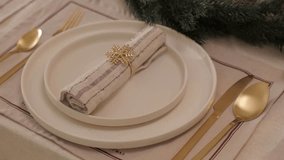 Elegant christmas table setting showcases golden snowflake napkin rings, white plates, and gold cutlery, creating a festive atmosphere - Powered by Shutterstock - Get 15% off with code: PIKWIZARD15