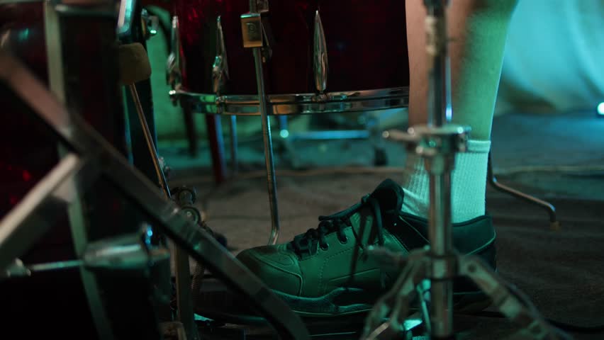 Drummer playing on concert, close up in studio, drummer hands hit the drum cymbal with drumstick in a dark studio. Drummer plays the drums in the recording studio. Music band rehearsal