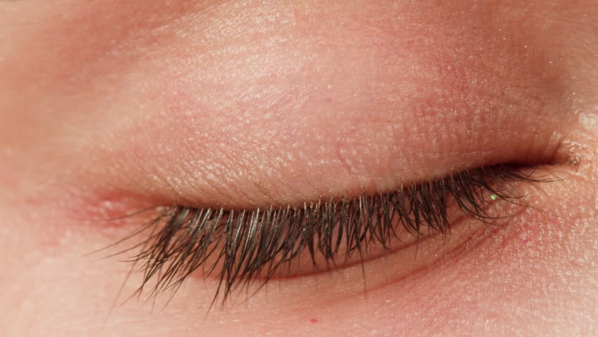 Close-up of green eyed woman with no make-up on face macro. Blinking eye with long lashes. Beauty skin care make-up routine