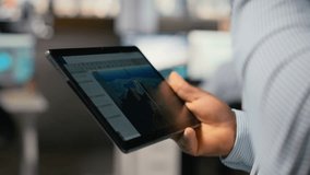 Close up of engineer in office using tablet to work on wind turbine CAD design, doing sustainable energy research. Worker doing digital modeling of wind energy generator gear on device, camera B - Powered by Shutterstock - Get 15% off with code: PIKWIZARD15