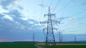 Power lines stretch across a serene sunset landscape, with silhouetted electricity pylons against a vibrant sky, symbolizing sustainable energy infrastructure and modern power distribution. - Powered by Shutterstock - Get 15% off with code: PIKWIZARD15
