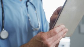 caucasian male doctor wearing face mask using digital tablet 4k video - Powered by Shutterstock - Get 15% off with code: PIKWIZARD15