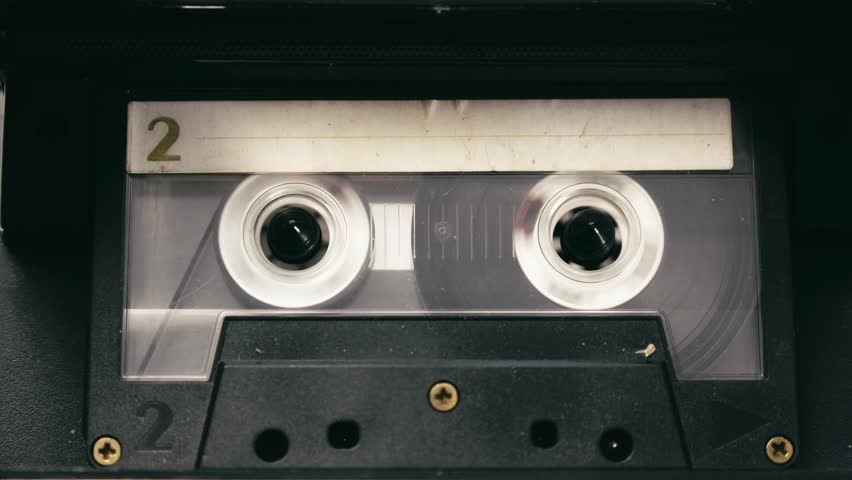 Tape recorder cassette rewind action, stops then plays media CLOSE-UP