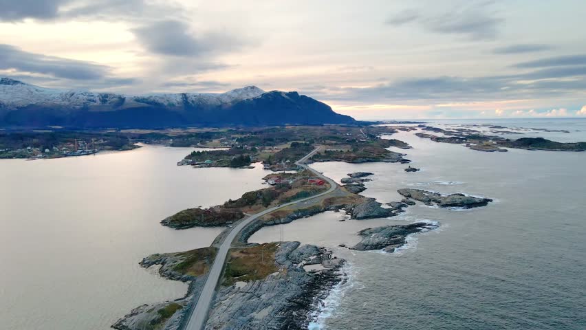 An aerial view captures the iconic Atlantic Ocean Road Atlanterhavsveien in Norway, showcasing its dramatic bridges connecting small islands and islets across the rugged coastline.