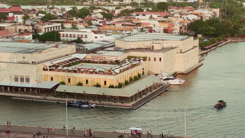 Orbital aerial shot of convention center with tourists enjoying sunset, cartagena de indias, colombia