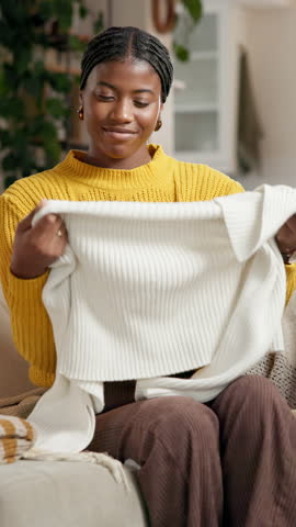Smelling, clothes and black woman in home for housekeeping, maintenance or spring cleaning. Happy, fabric and African female person with scent on material of laundry in living room at apartment.