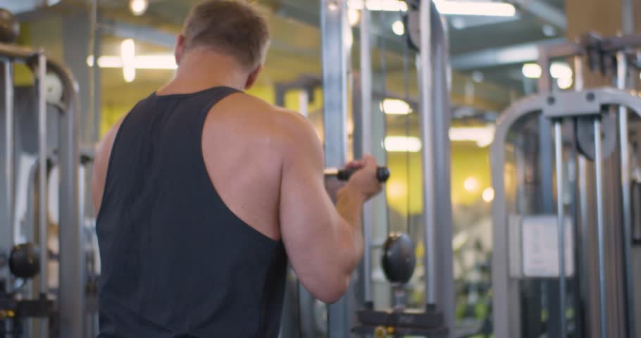 Gym workout. Bicep exercise. Middle aged Caucasian man trains his bicep muscles in the gym. Focused gym session as man performs bicep exercises to sculpt and strengthen his arms effectively.