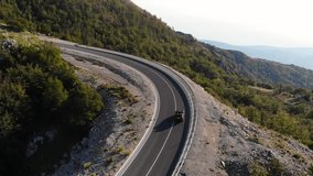 Scenic aerial view of a winding mountain road as a red convertible car navigates the curves, showcasing the beauty of nature and the thrill of driving through picturesque landscapes - Powered by Shutterstock - Get 15% off with code: PIKWIZARD15
