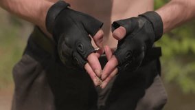 Close-up of shirtless soldier wearing head band, holding wet sand between fingers while preparing to apply it to face as part of intense outdoor ritual surrounded by nature and sunlight. - Powered by Shutterstock - Get 15% off with code: PIKWIZARD15