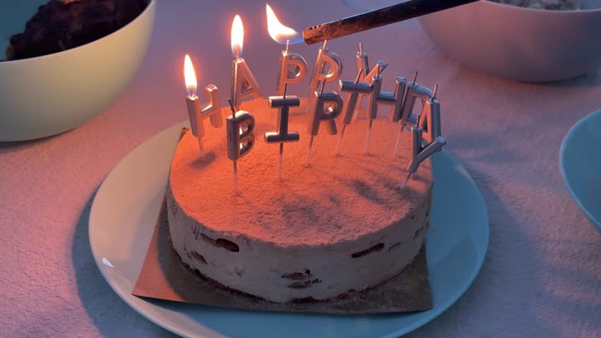 Lighting happy birthday candles on cake with lighter during celebration