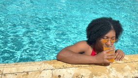 Young woman relaxing in a swimming pool, drinking juice and floating - Powered by Shutterstock - Get 15% off with code: PIKWIZARD15