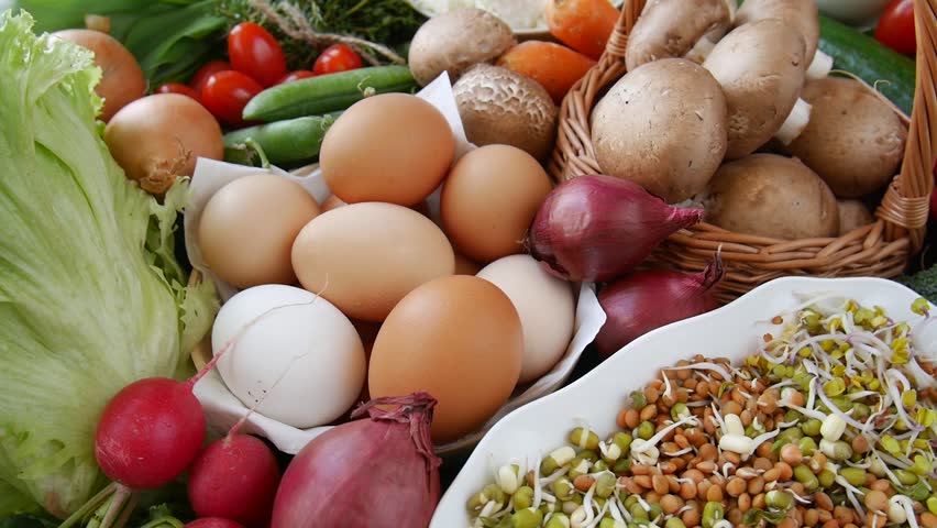 Composition of healthy food including vegetables, eggs, dairy products, and sprouts.