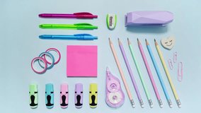 Pink pencil case packs colorful stationery in stop motion on light blue, leaving wide copy space, then reversing as a loop - Powered by Shutterstock - Get 15% off with code: PIKWIZARD15