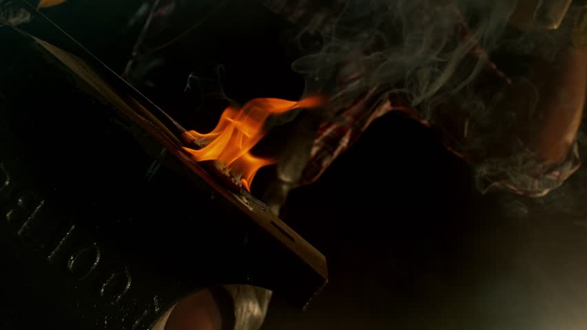 Close-up of blacksmith forging glowing hot iron on anvil with flying sparks. Super slow motion filmed on high-speed cinema camera at 1000 fps