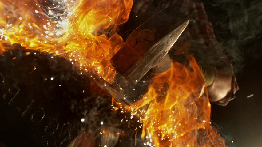 Close-up of blacksmith forging glowing hot iron on anvil with flying sparks. Super slow motion filmed on high-speed cinema camera at 1000 fps