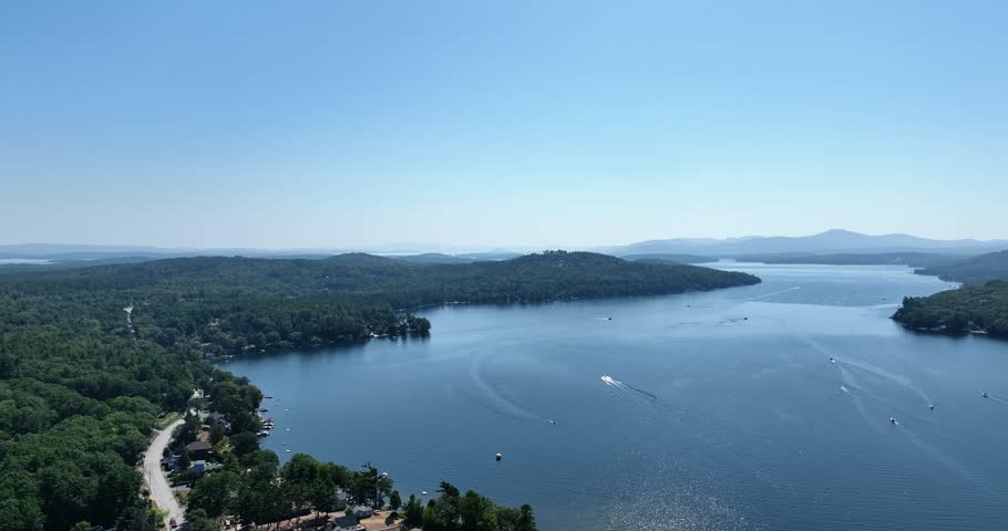 Aerial view of boats on a large lake in New England with mountains in the distance