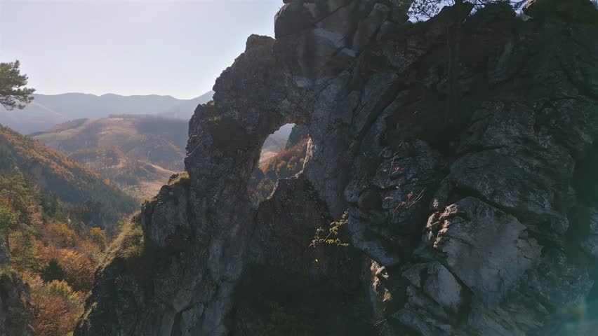 Flight by Rocky Window in Autumn Mountains