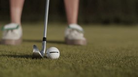 Lady golfer hits golf ball with steel driver on putting green - Powered by Shutterstock - Get 15% off with code: PIKWIZARD15