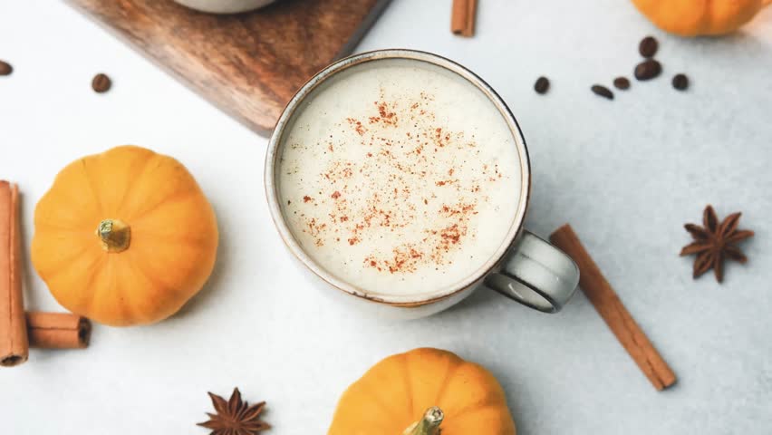 Hot drink with cinnamon and small pumpkins, autumn beverage with spices.
