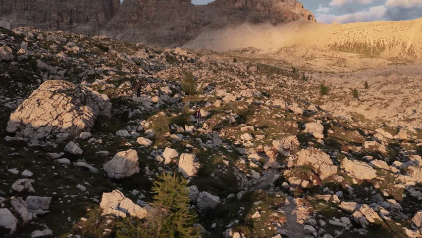 Hikers Walking Below Tre Cime di Lavaredo at Sunset, Dolomites