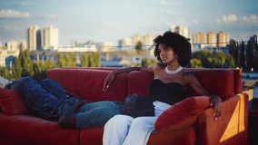 Black man lying on girlfriend's knees during rooftop fashion photoshoot - Powered by Shutterstock - Get 15% off with code: PIKWIZARD15