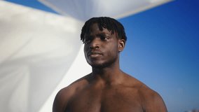 Shirtless African American man posing for camera, rooftop fashion photo shoot - Powered by Shutterstock - Get 15% off with code: PIKWIZARD15