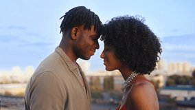 Smiling African American couple leaning foreheads, rooftop romantic moment - Powered by Shutterstock - Get 15% off with code: PIKWIZARD15