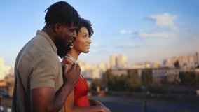 African American man hugging girlfriend, enjoying cityscape during rooftop date - Powered by Shutterstock - Get 15% off with code: PIKWIZARD15