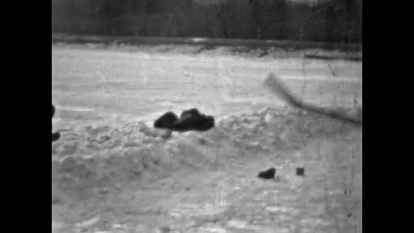 Adult happy men playing ice hockey on skating rink outdoors on winter snowy forest backdrop. Active healthy lifestyle. Hobby activity in snow sport. Vintage film. Old archive. Archival retro 1960s